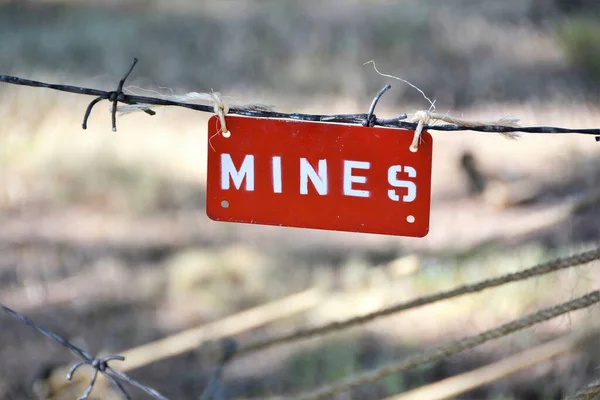 Buried land mines warning sign. Mines are often laid in groups, called minefields, and are designed to prevent the enemy from passing through a certain area.