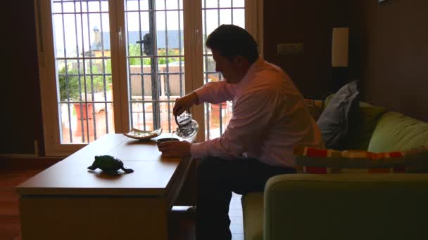 Homem a beber chá na sala de estar, hora do chá. 4K . — Vídeo de Stock