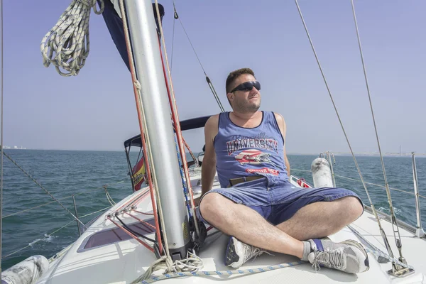 Male model sitting on sailboat sailing relaxed — Stock Photo, Image