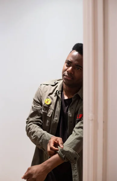 Afrikalı Amerikalı ceketini düzeltirken aynada kendine bakıyor.