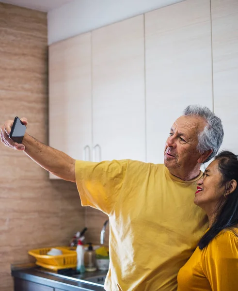 Orta yaşlı bir çiftin akıllı telefonuyla çekilmiş selfie.