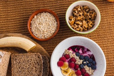 Kahverengi ekmek, fındık ve meyve tabağı ile sağlıklı bir kahvaltı. 