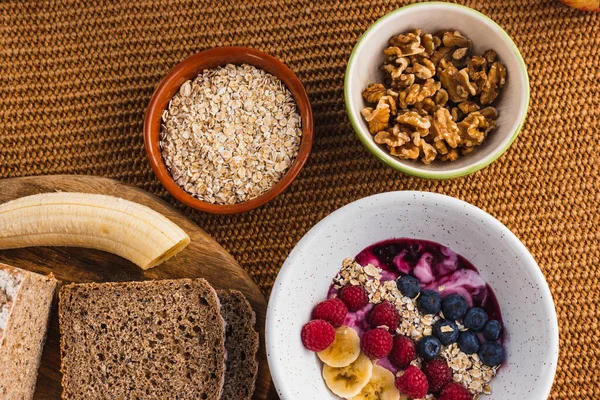 Kahverengi ekmek, fındık ve meyve tabağı ile sağlıklı bir kahvaltı. 