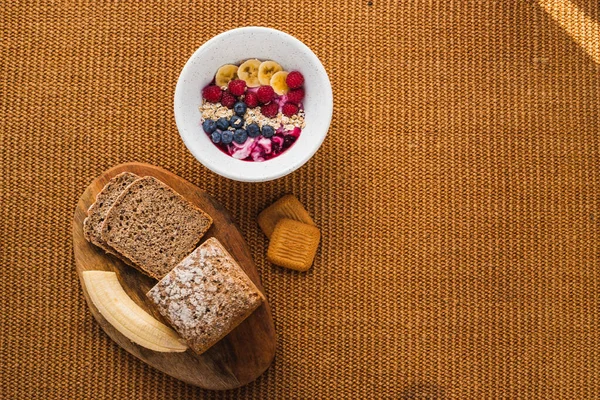 Kahverengi ekmek ve meyve tabağı ile en az sağlıklı kahvaltı.
