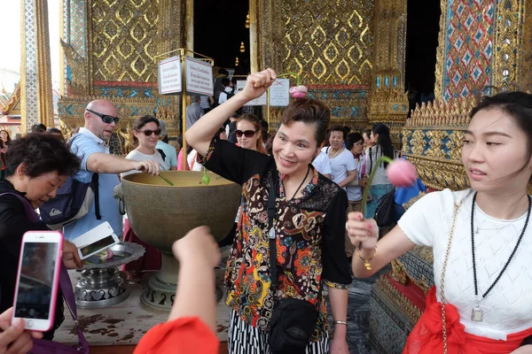 Nilüfer çiçekli turistler korunma ve sağlık için kutsal suyla yıkandılar, Büyük Saray, Bangkok, Tayland