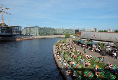 İnsanlar, Ren, Berlin, Almanya kıyılarındaki güneş pansiyonlarında dinleniyor.