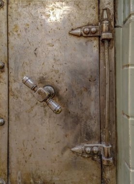 Eski bir evin odasındaki seramik bir sobanın yüzeyinde antika teçhizatlı fırın kapıları..