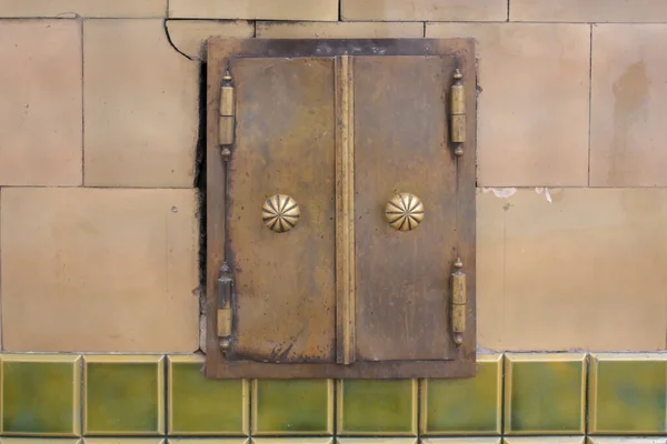 老房子房间里陶瓷炉灶表面装有老式配件的炉门 — 图库照片