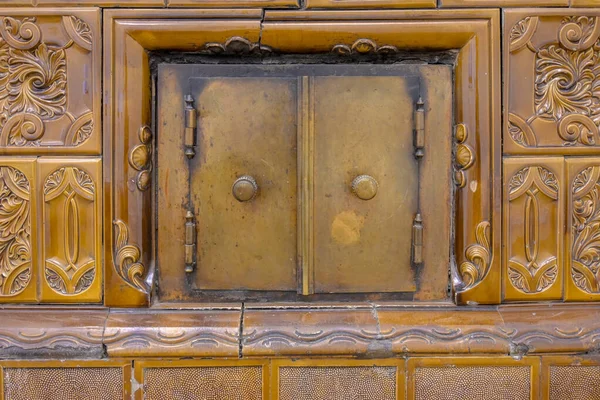 老房子房间里陶瓷炉灶表面装有老式配件的炉门 — 图库照片