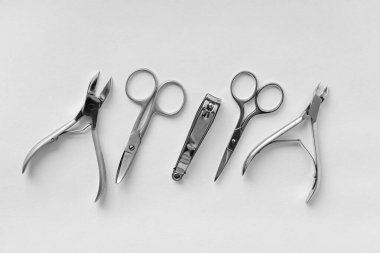 Hafif bir arka planda manikür ve pedikür için bir takım kozmetik aletler. Tırnak törpüsü, tırnak makası, satıcı ve pense üst görünüm.