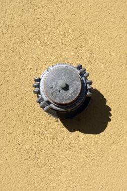 Yangın musluğu, sarı duvarın arka planına önden yakın çekim yapıyor. Yangın güvenliği. İtfaiye.