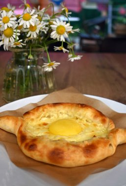 Ev yapımı peynirli ve yumurtalı Khachapuri-Ajarian turtası. Gürcistan geleneksel mutfağı, ev yapımı kekler. 