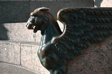 Bronz bir Griffin 'in kafası, St. Petersburg' daki Neva Embankındaki granit bir bankın arka planında. St. Petersburg 'un mimari detayları eski şehrin merkezinde..