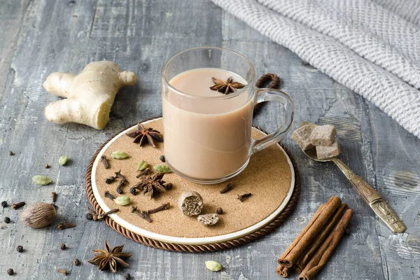 Masala tea is a national Indian tea with spices. It is a boiling mixture of milk and water with loose leaf tea, brown sugar or honey and whole spices: cardamom, cinnamon, ginger, fennel seeds, black pepper, cloves, nutmeg. Copy space. Close-up.