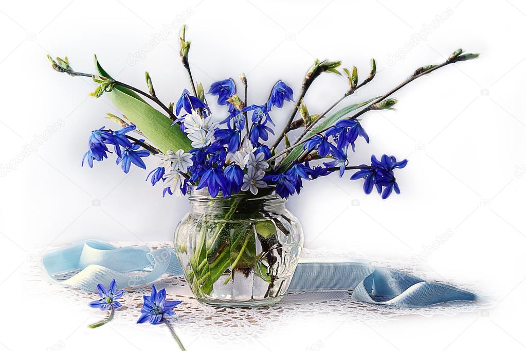 Blue flowers in spring water in a glass vase.