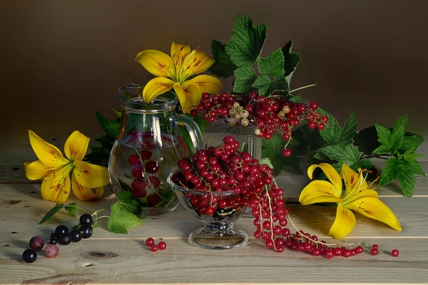 Vörös bogyós gyümölcsök váza és sárga liliomban . — Stock Fotó