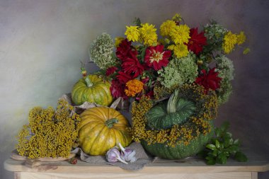 Olgun balkabaklarını topla ve masanın üzerinde güzel bir buket çiçek..