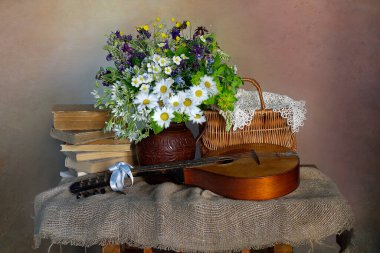 Bir buket güzel çiçekle ve masada müzik aleti ile durgun bir hayat..