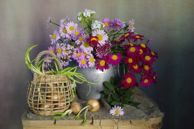 Papatyalar ve soğanlarla dolu bir sepetin içinde