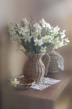 Kahverengi bir arka planda vazoda duran bir buket nergis çiçeği..