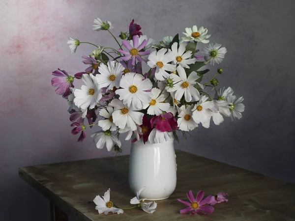 Papatyalarla hayat, çok renkli bir arka planda kozmetik. Buketteki bahçe çiçekleri..