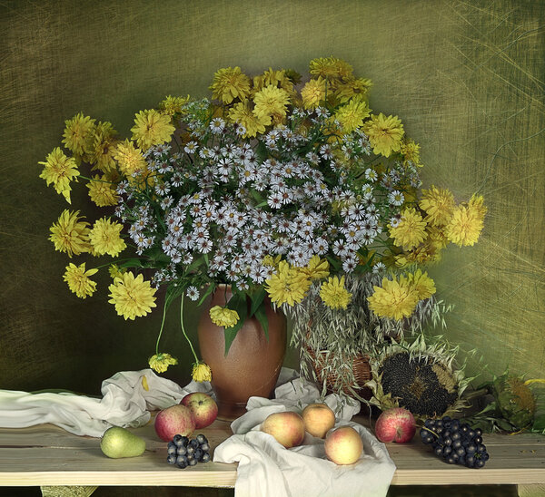 Floral arrangement of Golden orbs and daisies with fruit