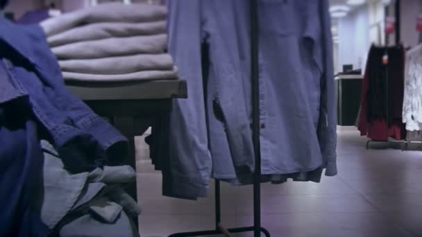Estantes con ropa de mezclilla en la tienda — Vídeos de Stock