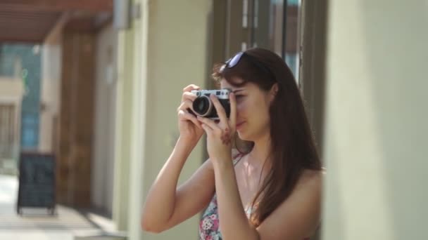 Una chica sosteniendo una cámara vintage — Vídeos de Stock