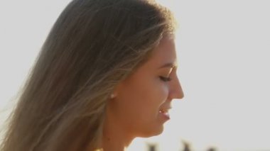 Sahilde kız. gün batımında saçında rüzgar ile