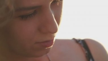 Sahilde kız. gün batımında saçında rüzgar ile