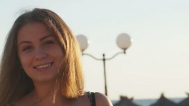 Genç kız smartphone ile sahilde. Günbatımı