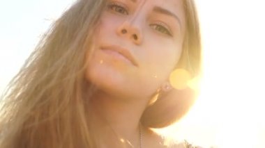 Sahilde kız. gün batımında saçında rüzgar ile