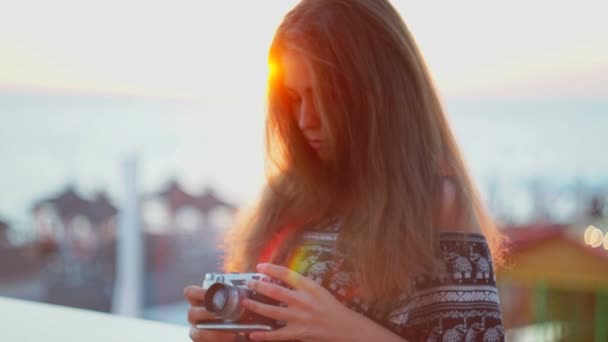Κορίτσι με μια vintage φωτογραφική μηχανή. Παραλία, ηλιοβασίλεμα, άνεμος — Αρχείο Βίντεο