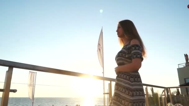 Mädchen am Strand. bei Sonnenuntergang mit ihren Haaren im Wind — Stockvideo