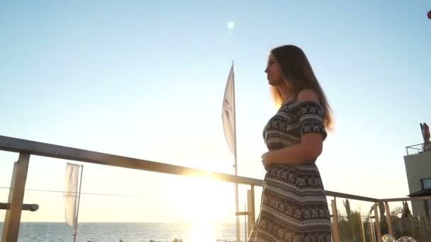 Una chica en la playa. al atardecer con su pelo en el viento — Vídeos de Stock