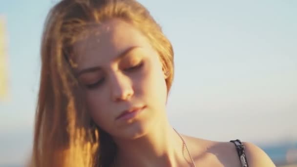 Une fille sur la plage. au coucher du soleil avec ses cheveux dans le vent — Video