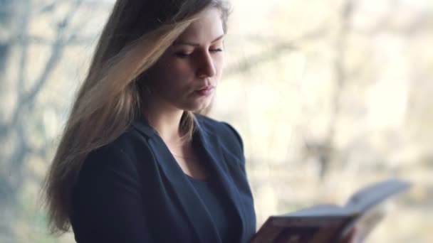 Meisje student leest een boek. buitenshuis — Stockvideo