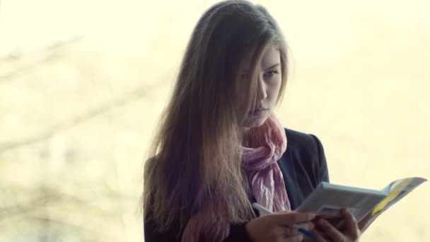 Jonge student schrijven in een notitieblok — Stockvideo