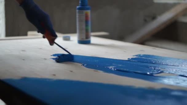 Taller de pintura. Carpintero pintura superficie de madera con azul — Vídeo de stock