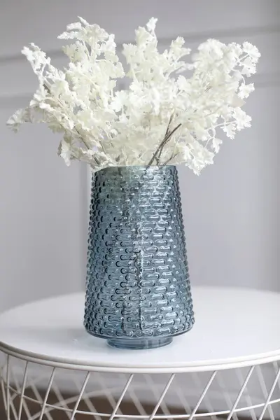 Masasında çiçekler olan vazo.