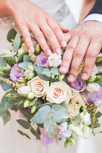 Foto de una feliz pareja de recién casados sosteniendo un ramo — Foto de Stock