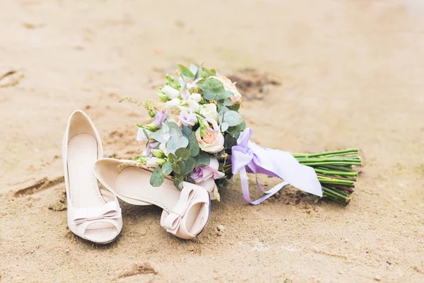 Bela composição boho com um buquê de noiva e sapatos de casamento — Fotografia de Stock