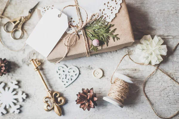 Уютный винтажный тонизированные зимние праздники Рождественская композиция с подарками коробки и мячи, сосновые шишки деревянный фон — стоковое фото