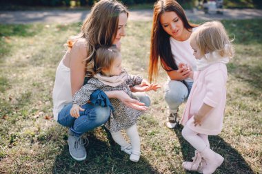 Genç bir aile parkta yürüyor.