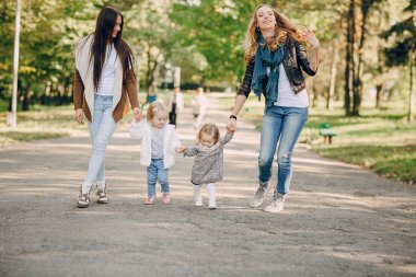 Genç bir aile parkta yürüyor.