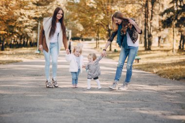 Genç bir aile parkta yürüyor.