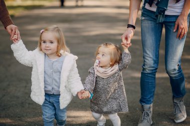Genç bir aile parkta yürüyor.