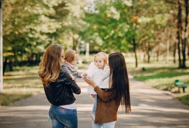 Genç bir aile parkta yürüyor.