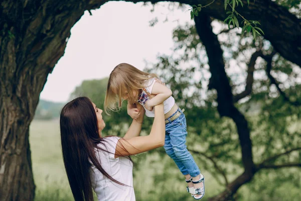 Kind in de buurt van boom met moeder — Stockfoto