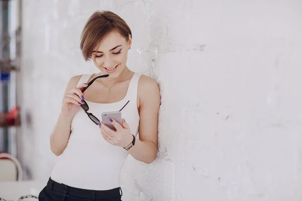 Het meisje maakt gebruik van haar telefoon — Stockfoto